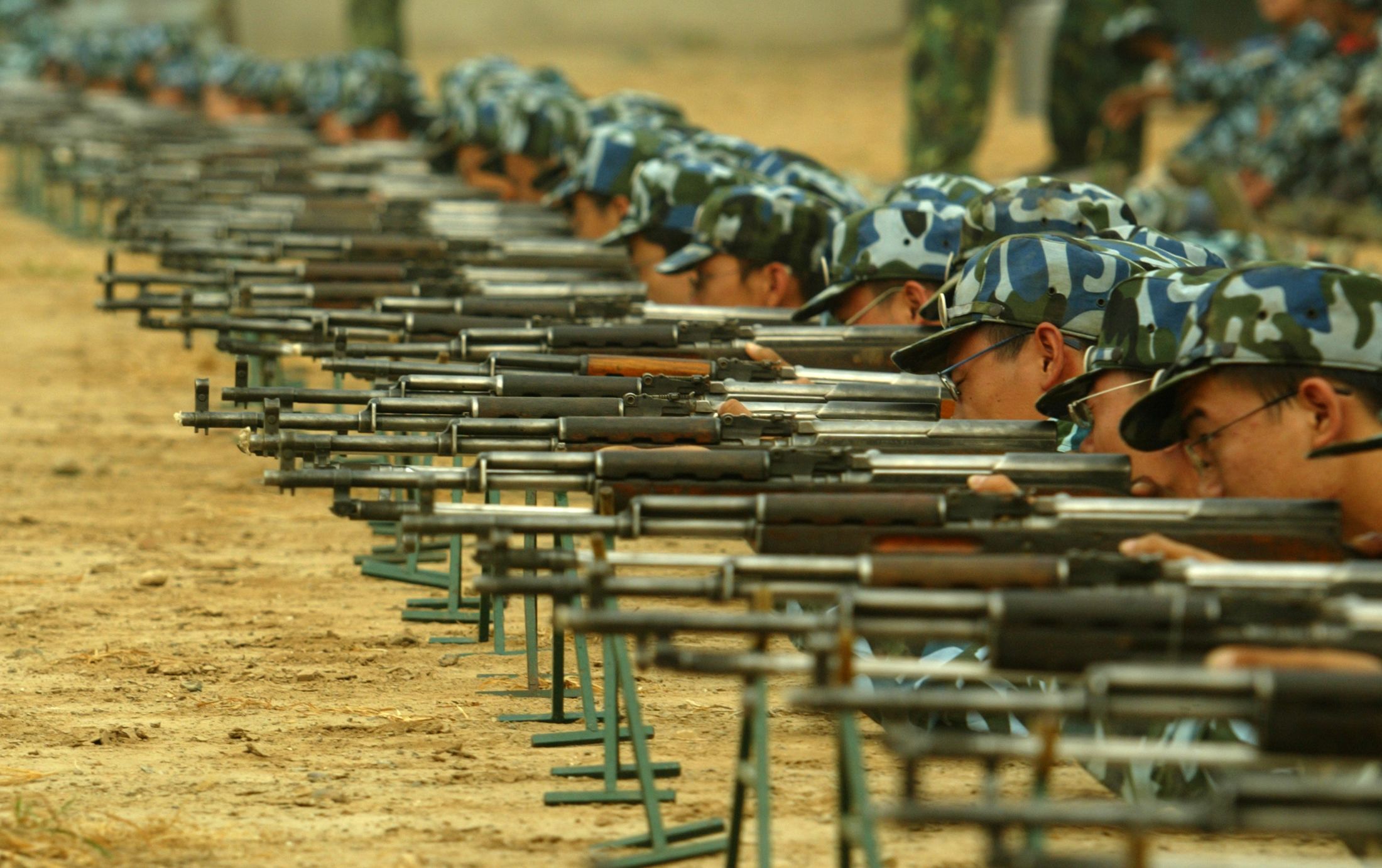 2005年8月29日，北京清华大学新生在为期三周的军训期间参加射击练习。（REUTERS / Cheng Jin）