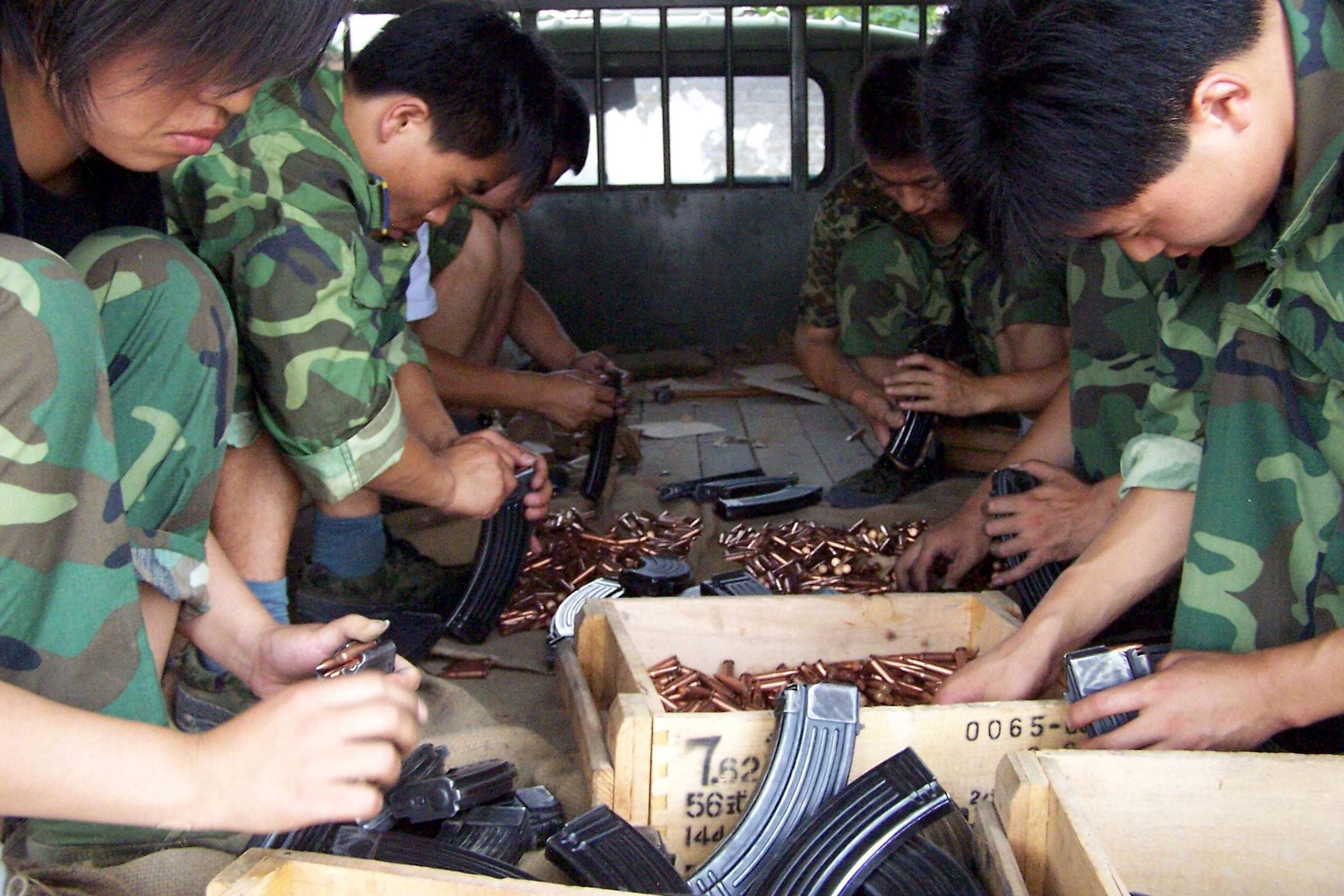 2004年7月2日，陕西省西安市，一个军事射击场中，中国学生在射击前将实弹装入步枪的弹匣。（REUTERS）