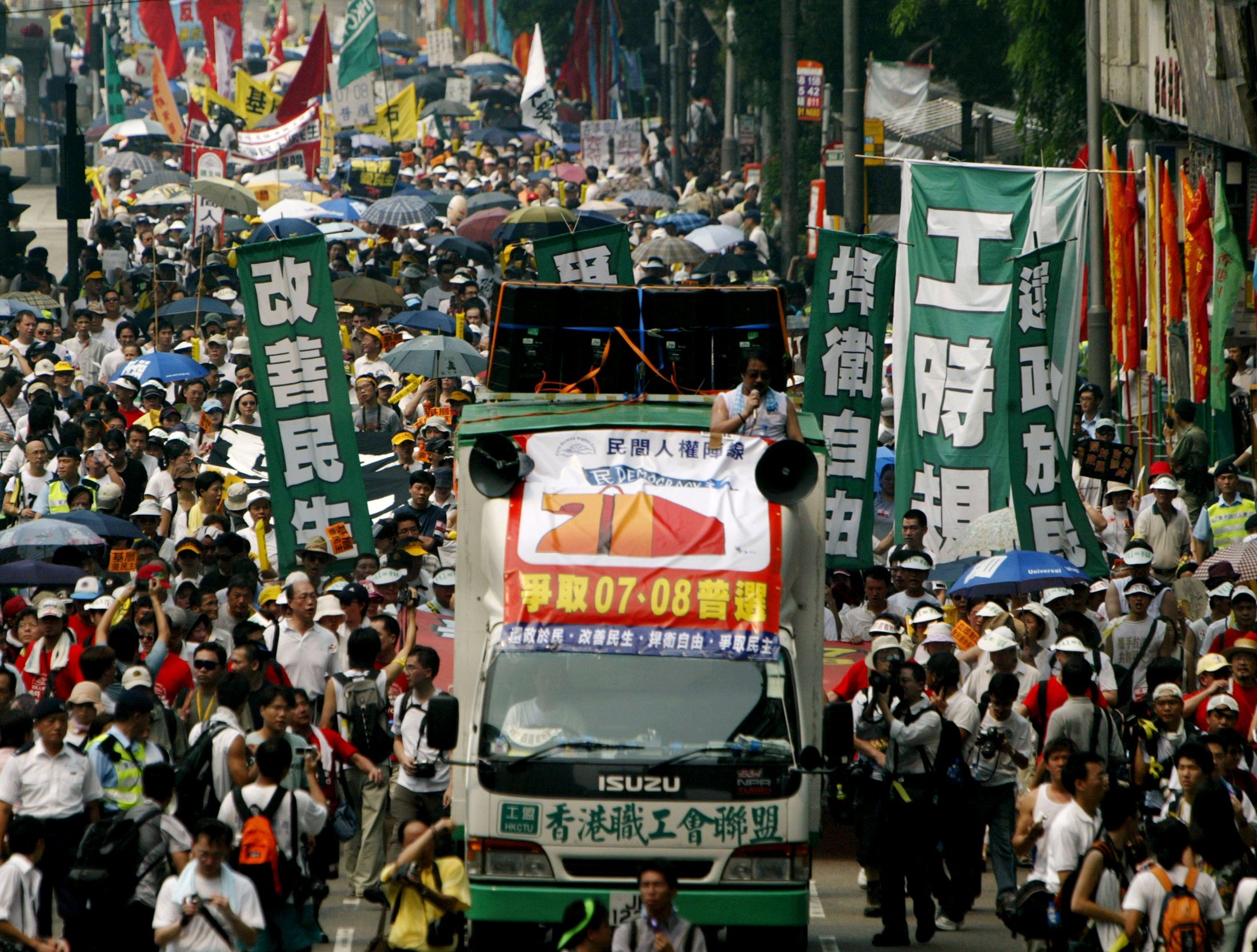 2004年7月1日，香港抗议人群在高温下游行，争取此前中方承诺的“双普选”：2007年普选行政长官、2008年立法会全面直选。当天气温接近35度，为当时香港历史上最高温的七一。全国人民代表大会常务委员会在该年否决了香港人于07、08年实现双普选的诉求。（Reuters/Bobby Yip）