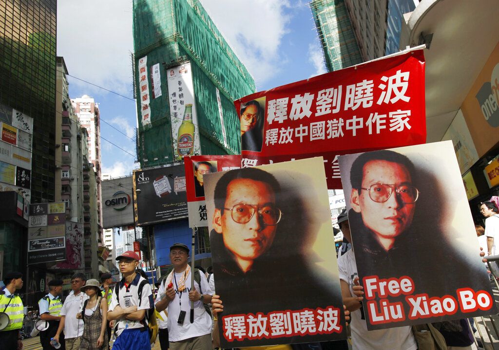 2009年7月1日，香港示威人群打出“释放刘晓波”的大幅标识。人权活动家刘晓波在2008年因参与起草《零八宪章》而被以“涉嫌煽动颠覆国家政权罪”刑事拘留，并在2009年6月23日被正式批捕。该年七一，首次有记录有游行示威人群在游行结束后于政府总部门外静坐抗议，凌晨，遭到警方武力清场，数百人被拘捕。往后一些年份，游行结束后开始有部分人士于政治地标留守至深夜。（AP/Vincent Yu）