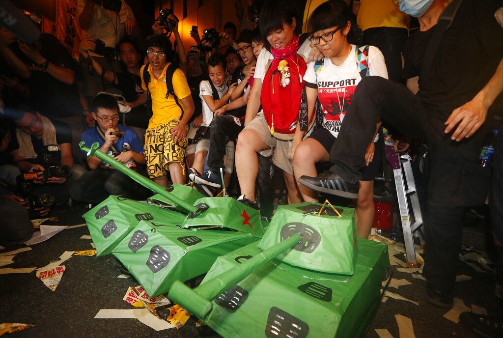 2012年7月1日，香港示威者愤怒地踩踏纸糊的解放军坦克模型。梁振英在当日正式宣誓成为香港第三任行政长官，激起香港民众强烈不满情绪。当年的游行主题为“踢走党官商勾结，捍卫自由争民主”。(AP Photo/Kin Cheung)