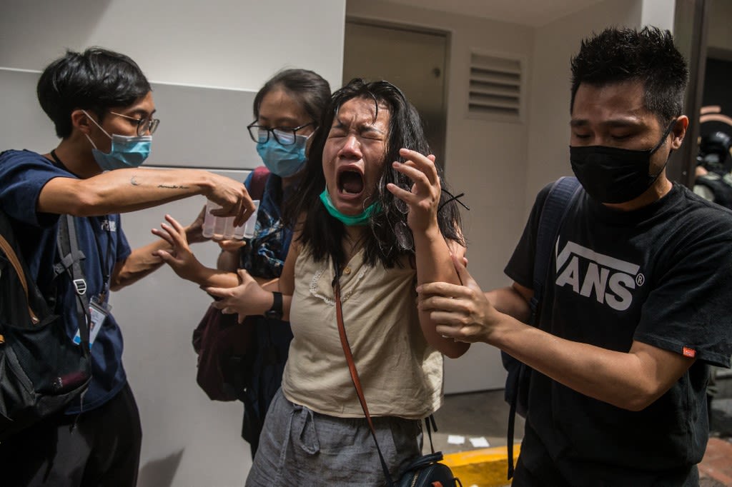 2020年7月1日，一名被警察胡椒喷雾喷中的女子。由于当年的游行被定性为非法，警察开始大规模对香港市民使用武力。（AFP/DALE DE LA KING）