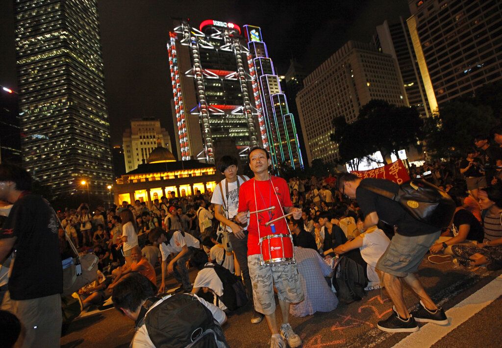 2011年7月1日，香港市民抗议游行上一名打鼓的抗议者。游行前，香港警方发布“不反对通知书“，并宣布任何人无合法权限或解释在公众或道路上奏玩乐器即属犯罪。当年的示威游行口号是“还我2012双普选，打倒地产霸权，曾荫权下台”。(AP/Vincent Yu)