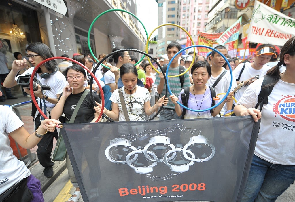 2008年7月1日，游行示威的人群打出手铐组成的五环标识，抵制北京奥运会。（AFP/Mike Clarke）  是年游行人数低于此前和此后年份，为一个谷值。