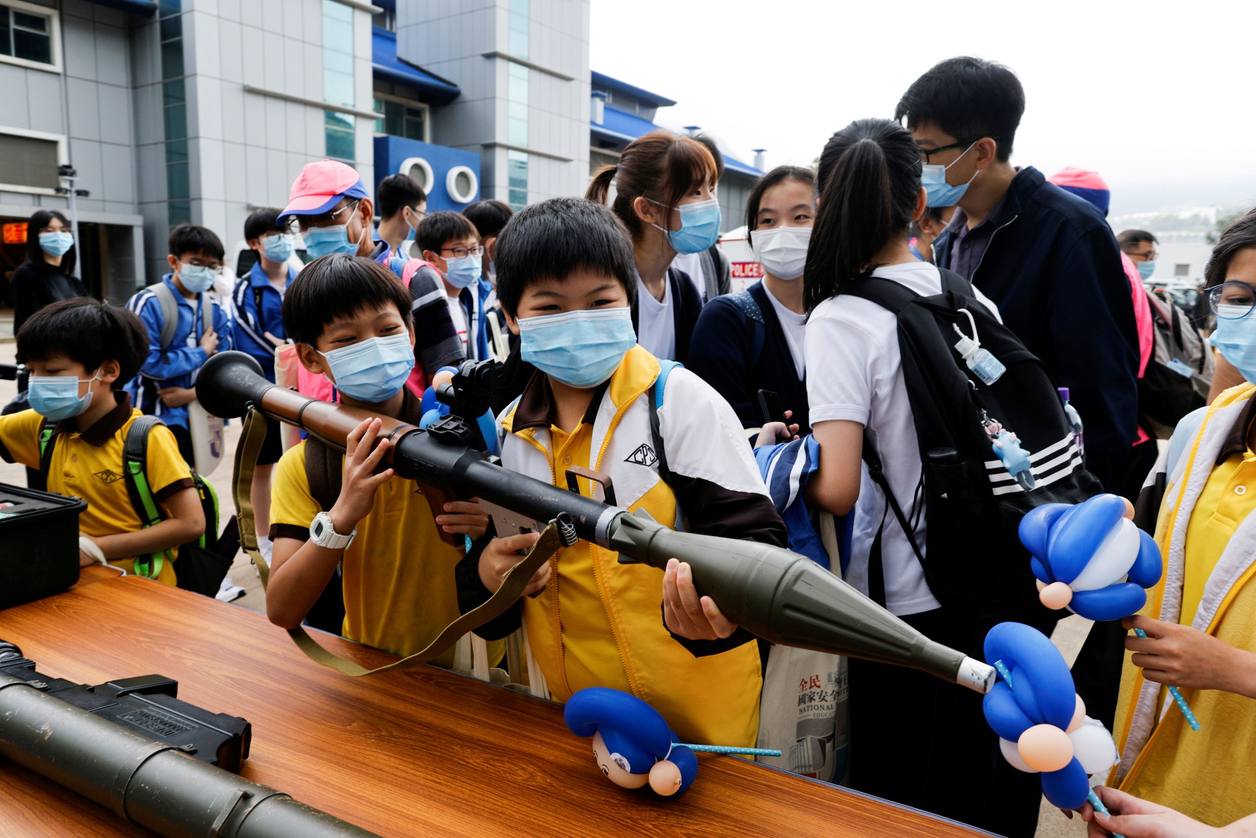 Children play with a mock grenade-launcher during National Security Education Day.