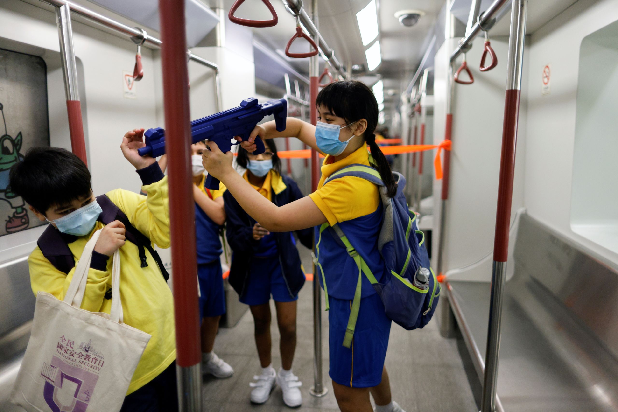 During the open day to mark the National Security Education Day at Hong Kong Police College, a child plays with a mock submachine gun at a model Mass Transit Railway (MTR) station  in Hong Kong. 