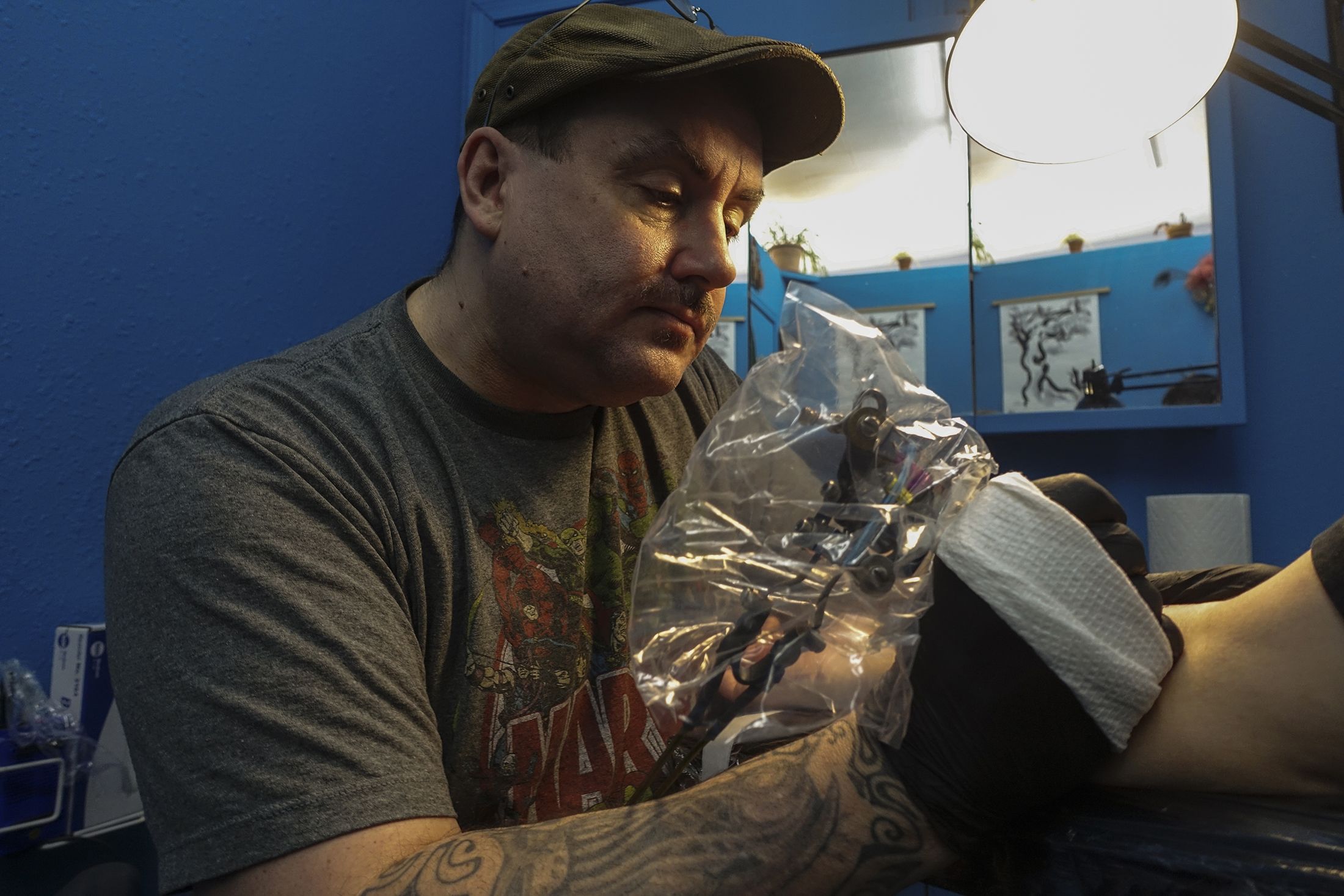 Sage在自己的工作室中为客户纹身。（歪脑/Shell Long)