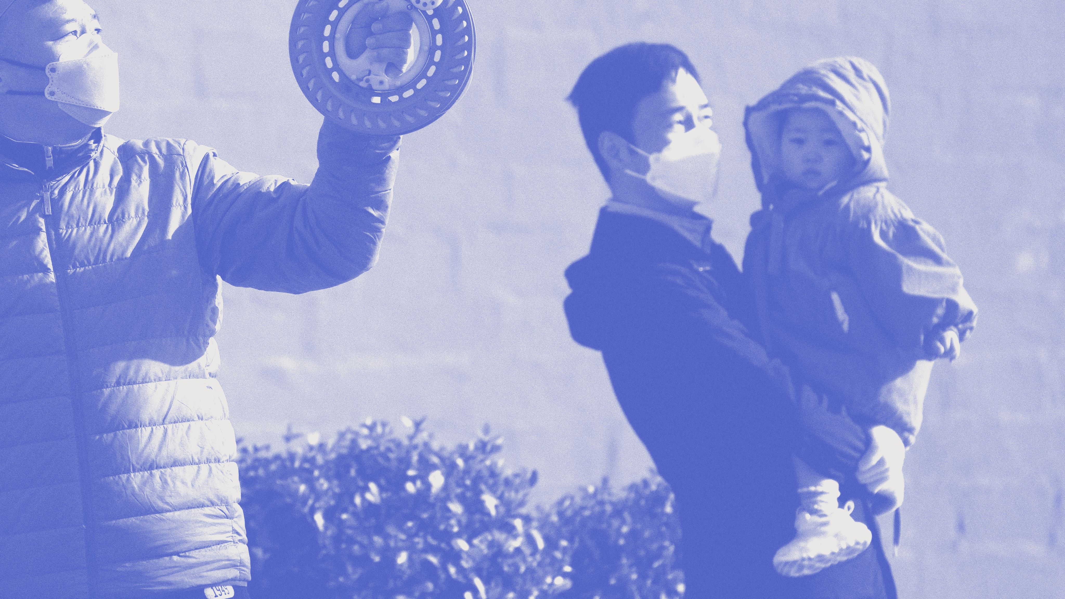 November 27, 2022, a man holds his child while watching residents fly kites in a park in Beijing. (AP / Andy Wong)