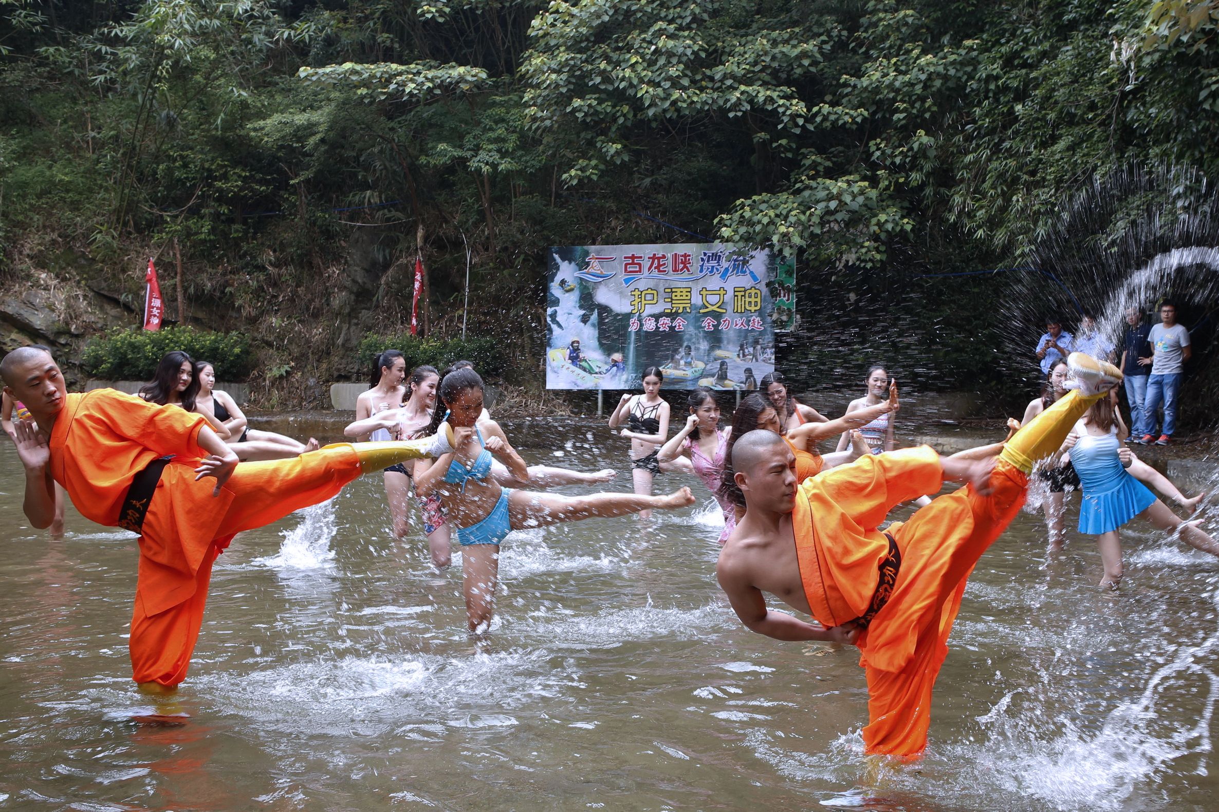 2016年6月17日，中国广东省清远市某景区中，一群身穿泳装的女性与少林僧人一起练习功夫。