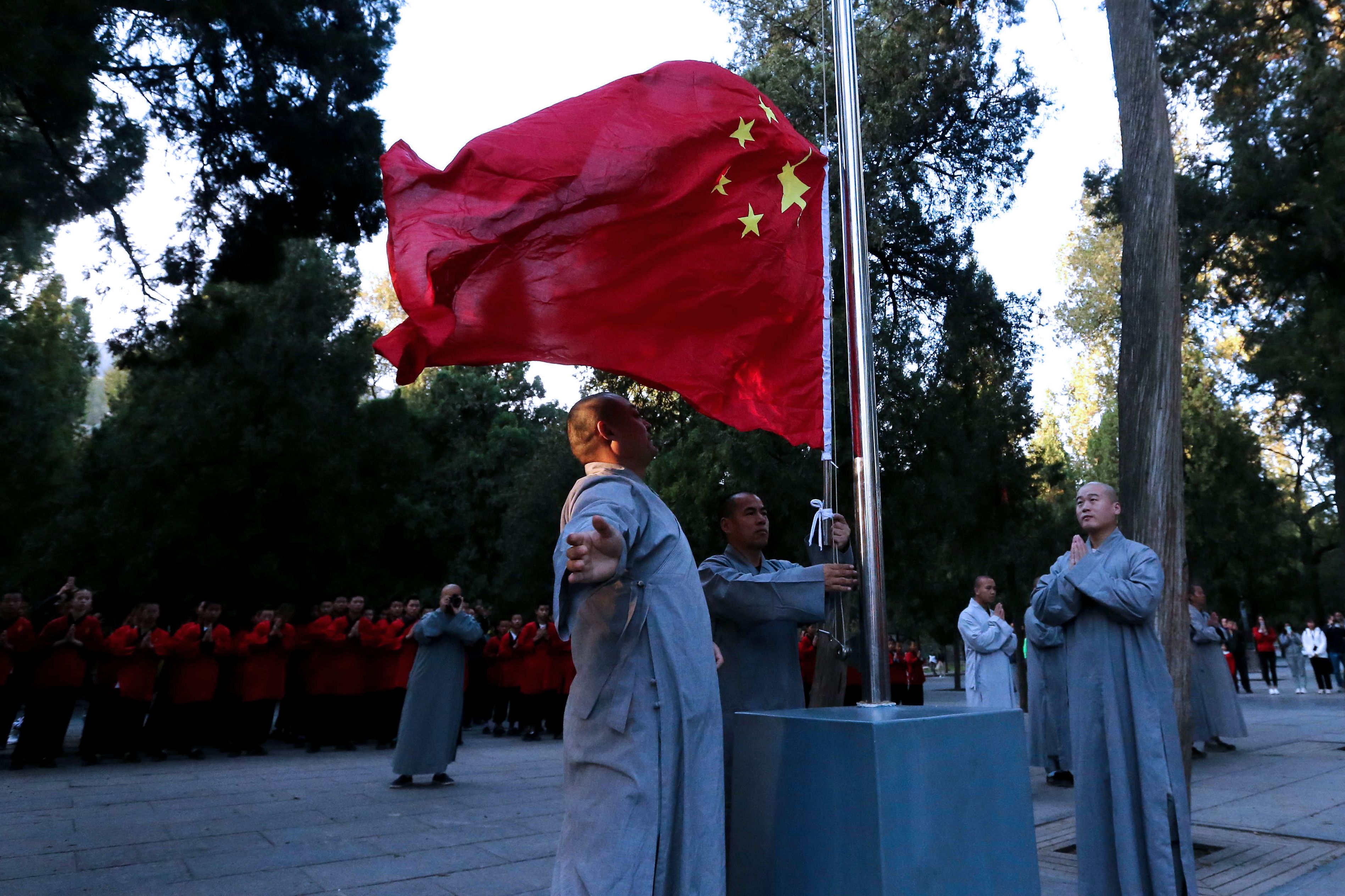 2018年10月1日，河南一间寺庙中，僧人在早晨举行升旗仪式。