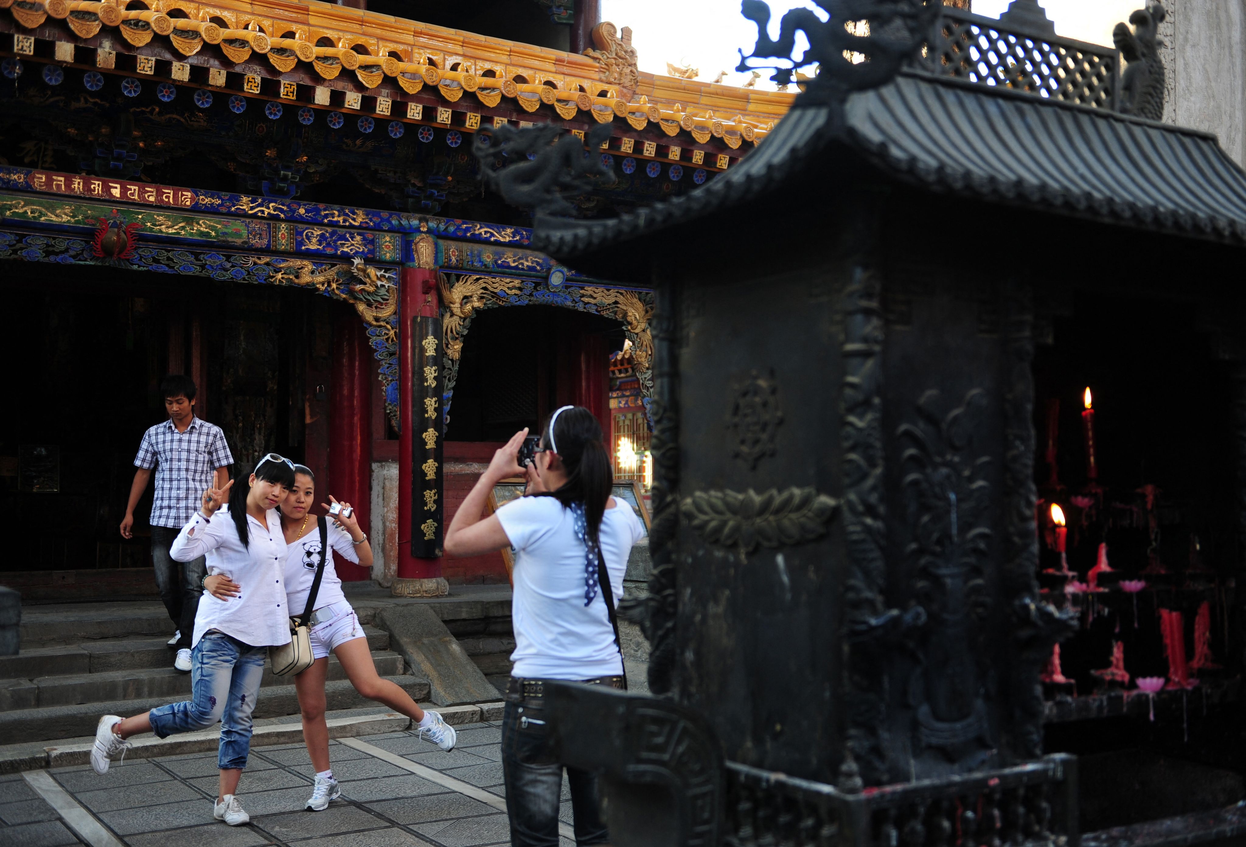 2009年6月24日，游客在中国北部山西省五台山的一座寺庙里摆姿势拍照。