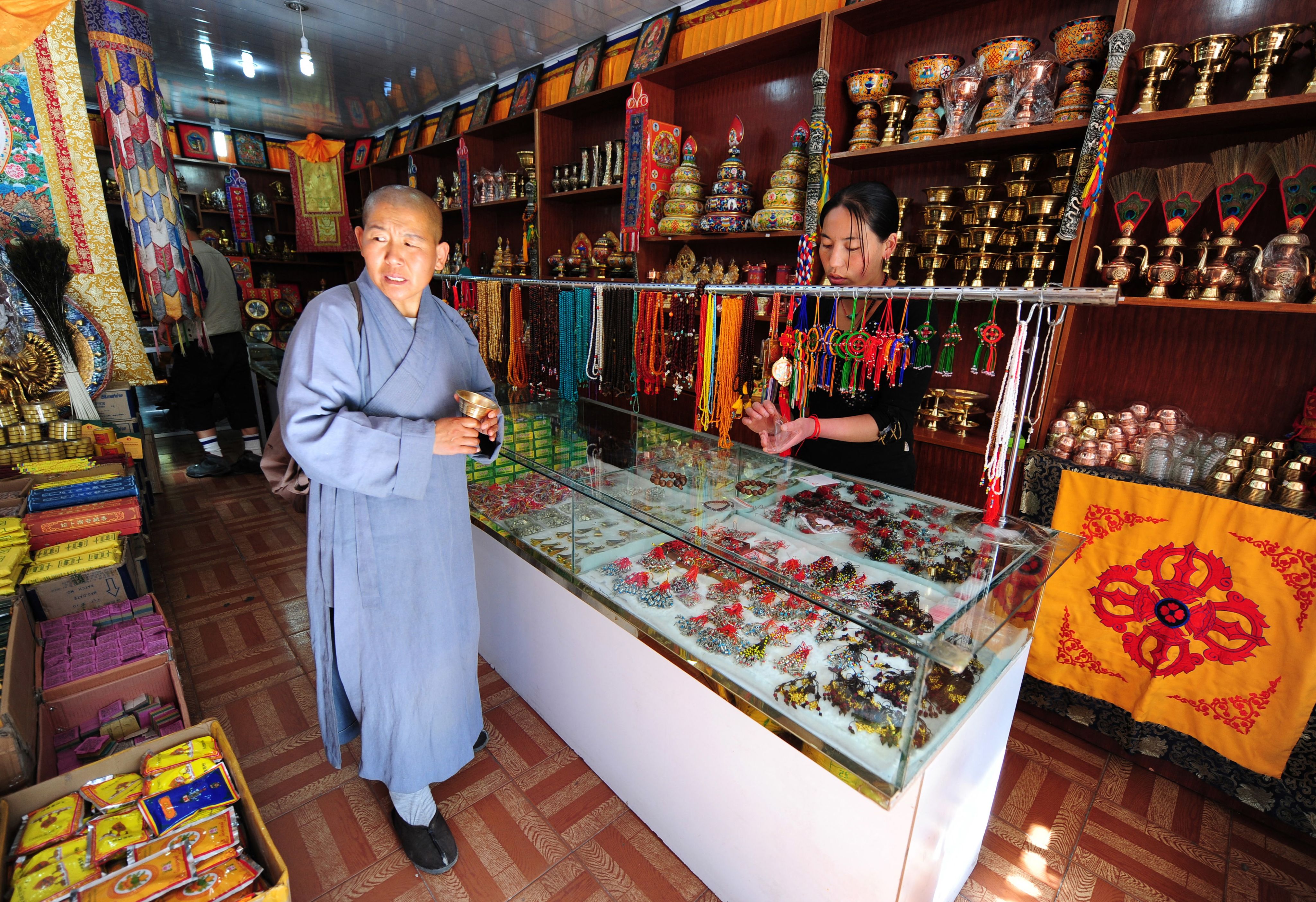 2009年6月24日，一名佛教僧人在五台山的一家商店购买小饰品。五台山位于中国北部的陕西省，寺庙繁多，僧侣们四处求道，信众挤满礼拜堂。