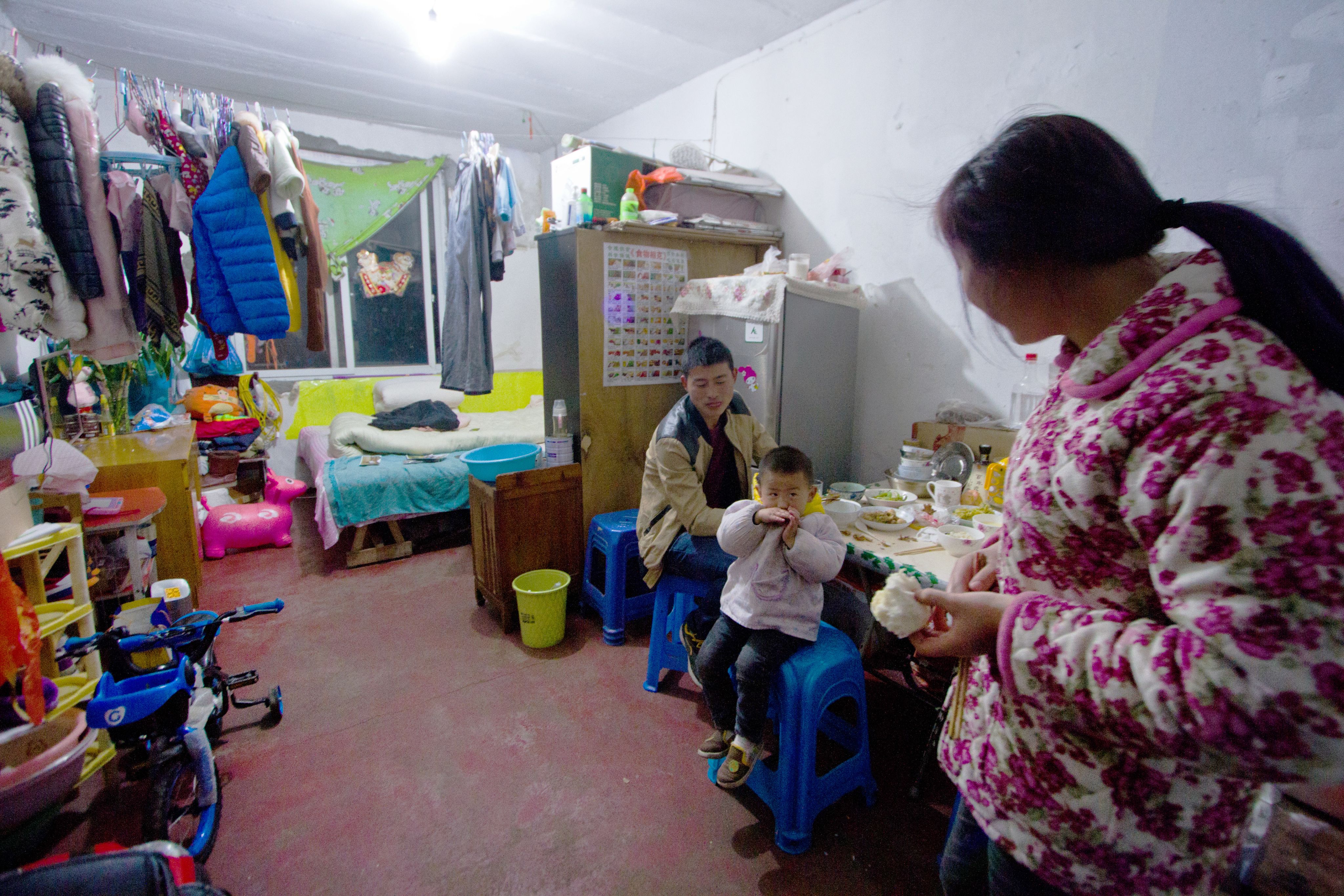 这栋建筑中，居住在十几平米房间内的外来务工家庭。冬天的阴雨天气下，他们只能在房间内晾干洗过的衣物，这也让房间内更加湿冷。（歪脑 / Shell Long)