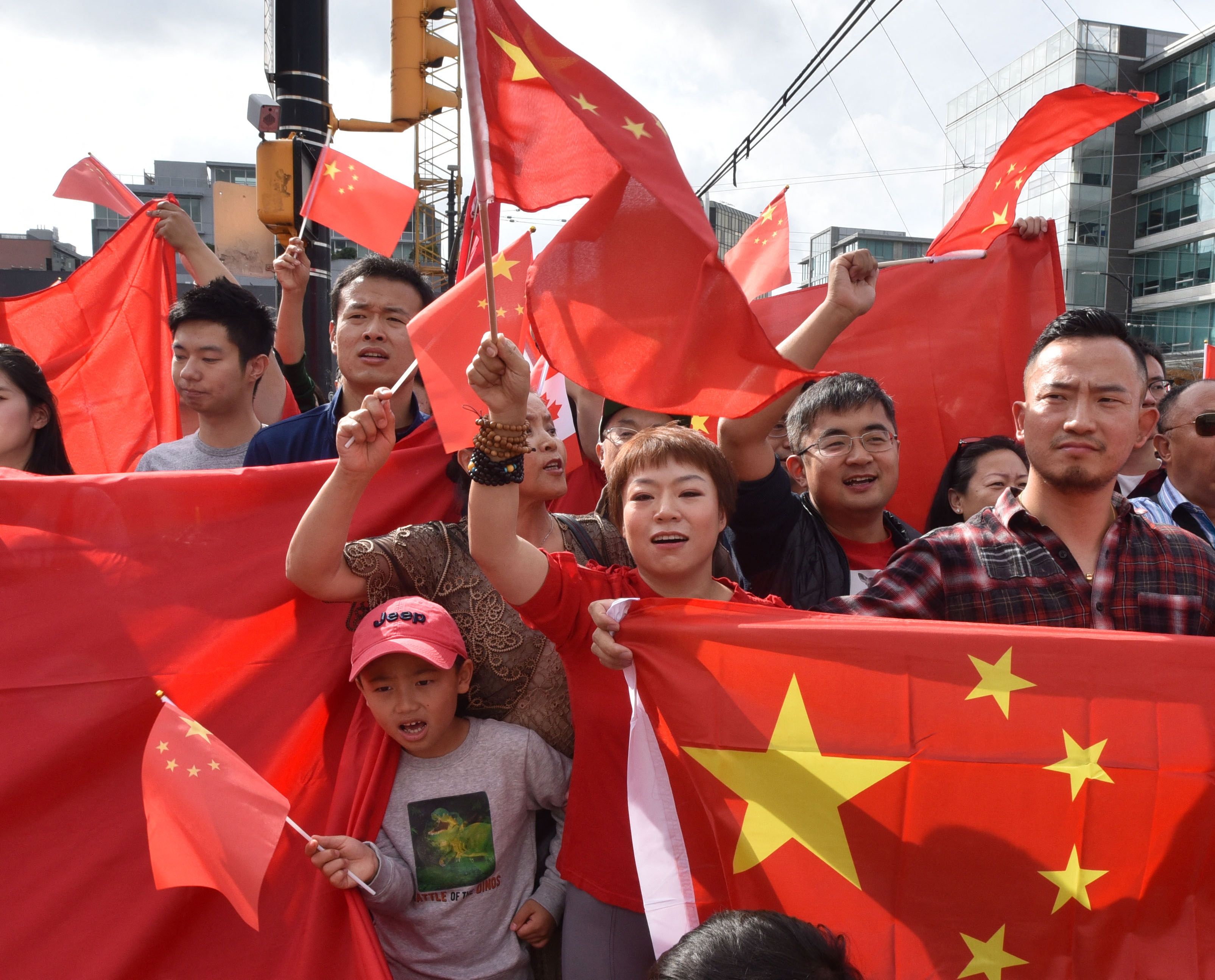在加拿大温哥华的“离岸爱国者”在一场2019年的香港运动集会中举着中国国旗。(AFP / Don MacKinnon)