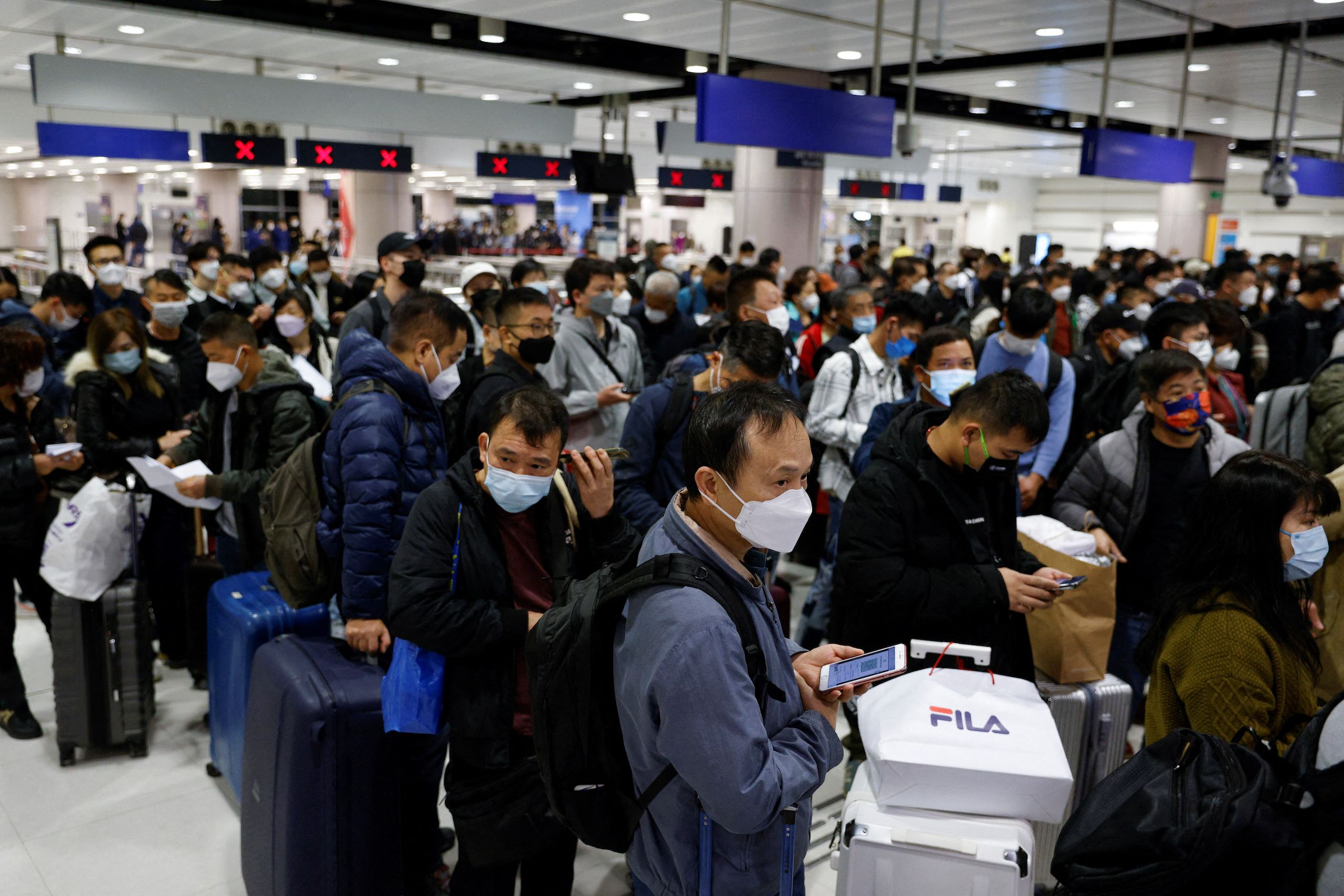 2023年1月8日，中港通关重新开放边境的第一天，旅客在香港落马洲边境检查站等待站门打开。