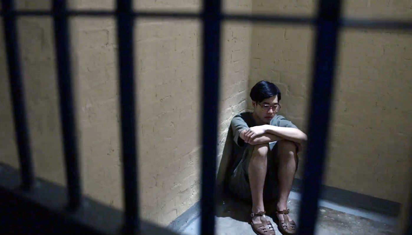 1967年少年犯杨宇杰与被控暴动待审的青年在狱中对谈的一幕（谭钧朗饰演）（《忧郁之岛》剧照）