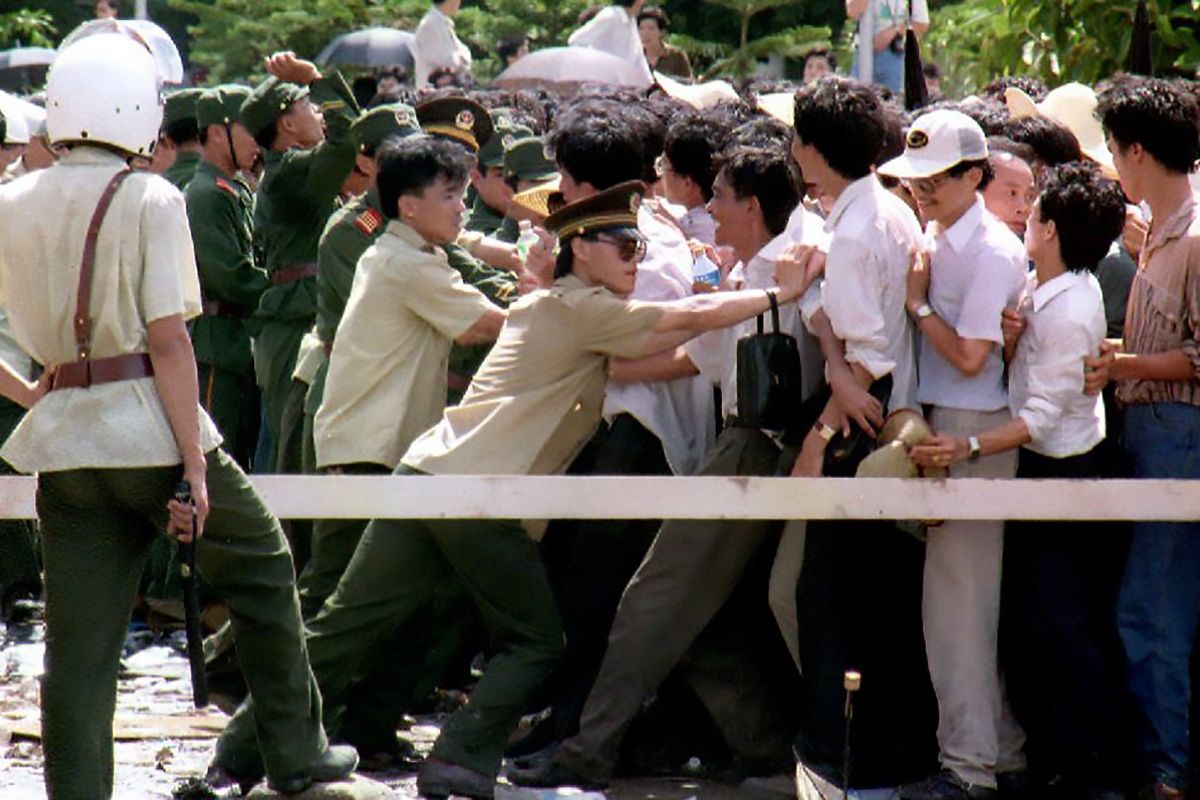 1992年8月11日，上海。上海证券交易所门前，警察试图阻止疯狂抢购股票的市民涌入交易所。（AFP / MICHEL PORRO）