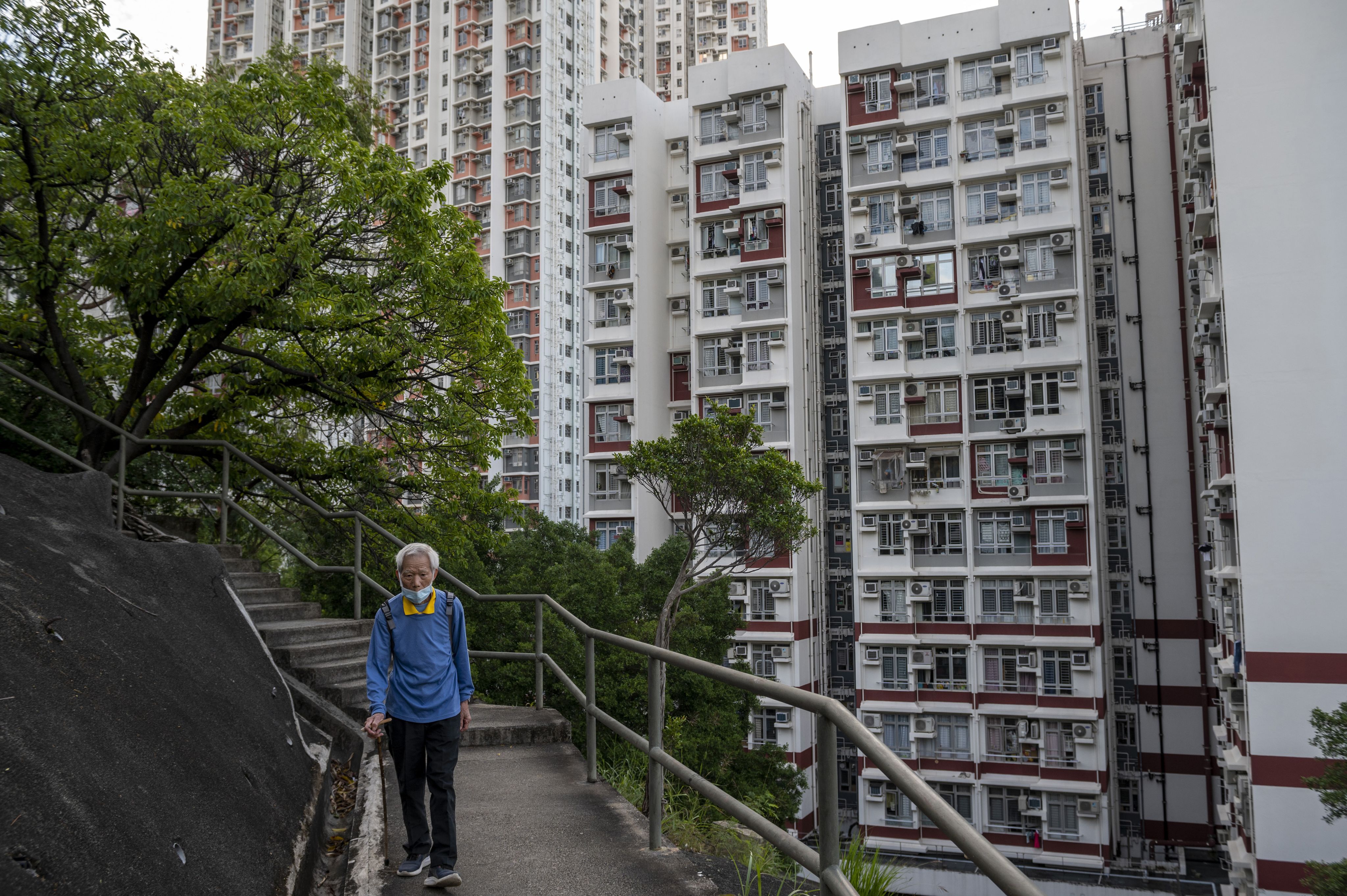 2021年10月5日，一名妇女走过北京销售办公室外展示各种待售和出租房产的广告牌。（ AP /Andy Wong）