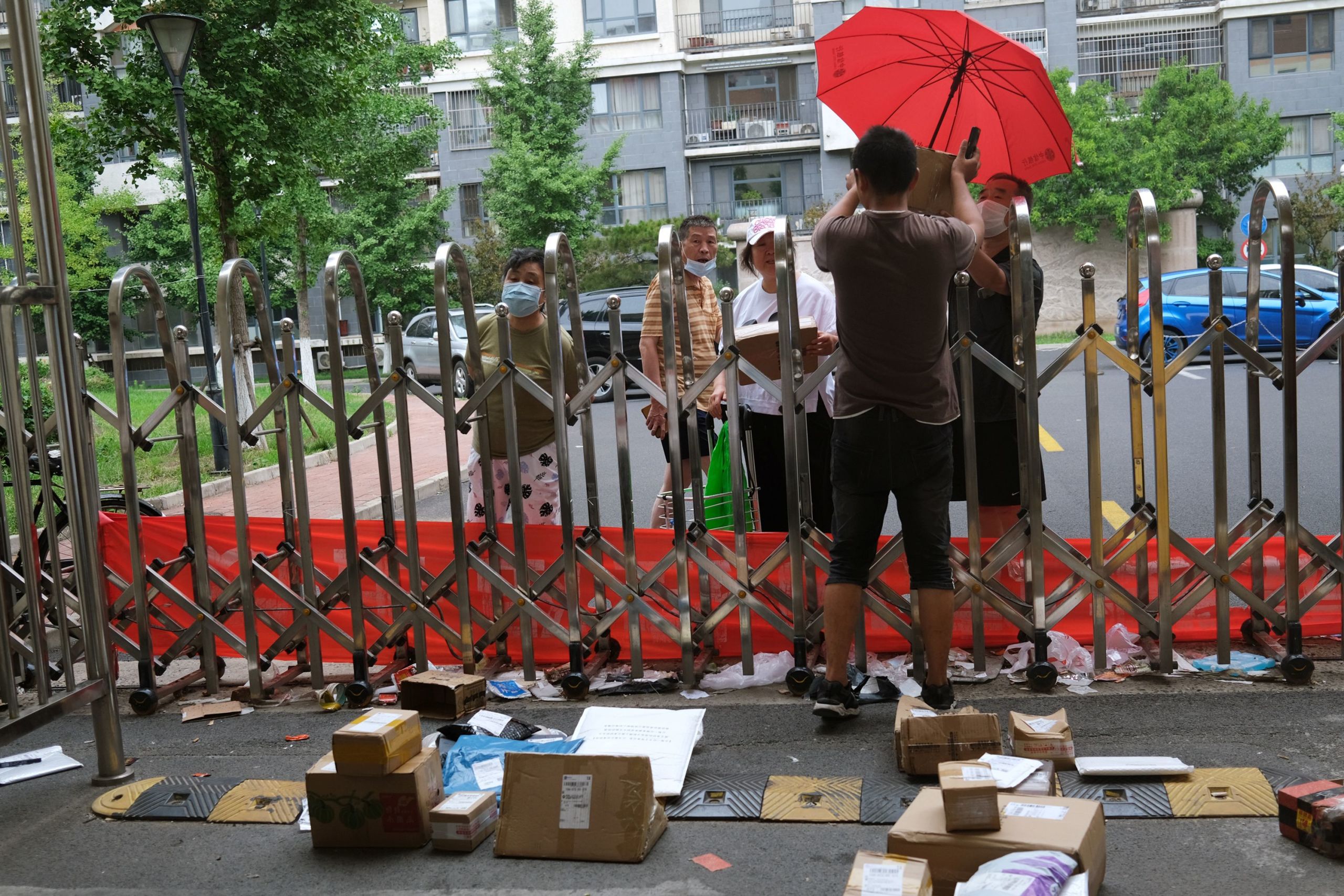 在北京爆发冠状病毒病 (COVID-19) 后，快递员将包裹集中放在小区门口（图片来源：REUTERS）