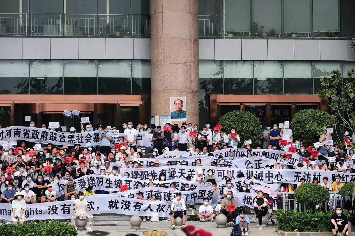 2022年7月10日，河南郑州市，约3000无法提取存款的河南村镇银行的储户聚集在中国人民银行郑州支行门前维权，并挂出“毛泽东像”。（网络图片）
