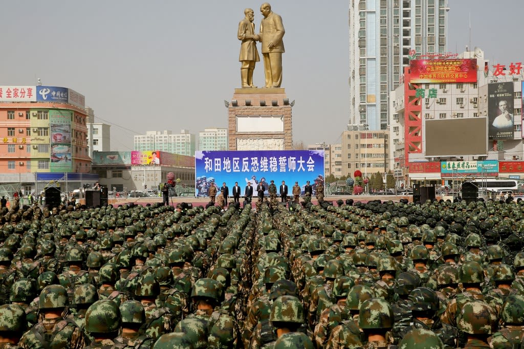 2017年2月27日，新疆和田市团结广场，中国武警在“毛泽东接见库尔班大叔雕像”前召开“反恐维稳誓师大会”。长久以来，中国官方都在新疆安排大量武力驻扎。（AFP）