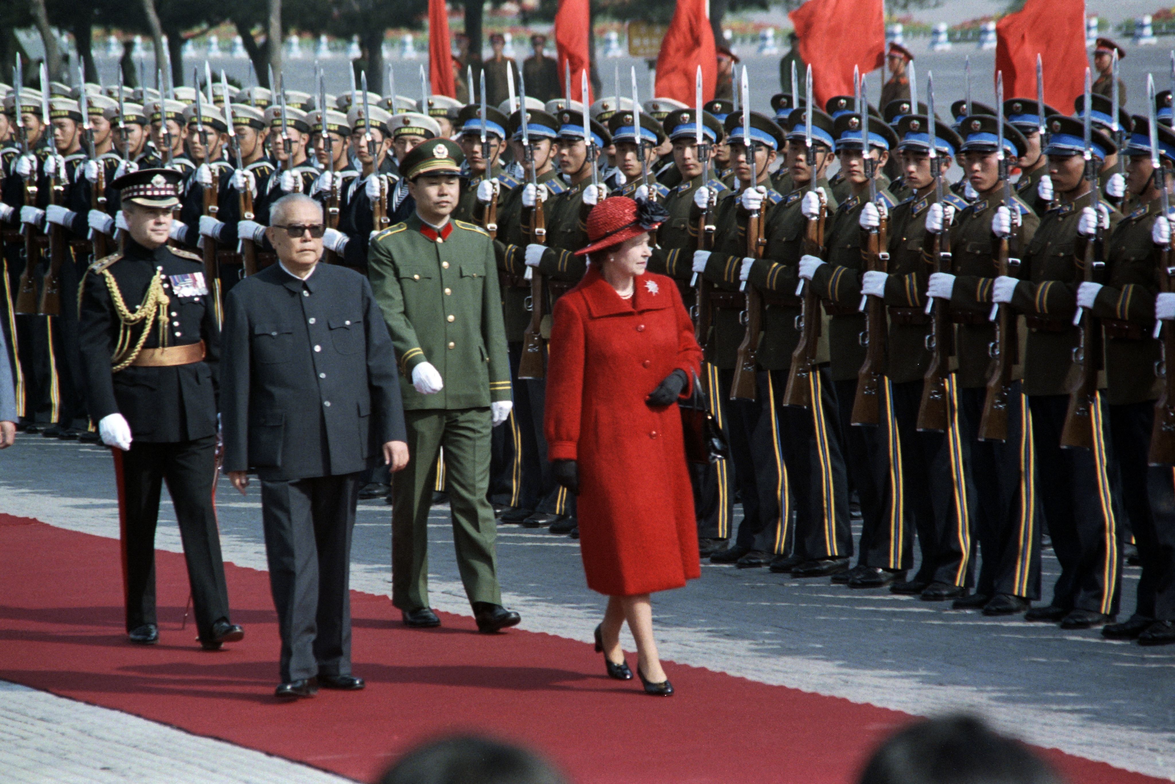 1986年10月13日，北京，英国女王伊丽莎白二世与时任中国国家主席李先念一同检阅仪仗队。 伊丽莎白二世在前日抵达北京机场，开始了她对中国的第一次为期六天的访问。(AFP / Walter LANDHOLT)