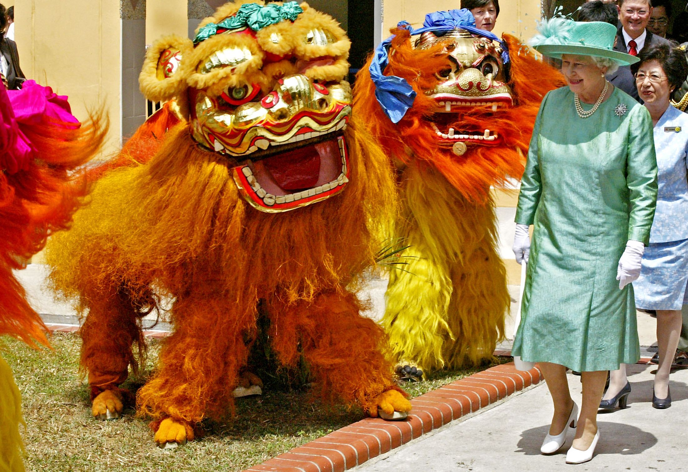 2006年3月7日，新加坡，英国女王伊丽莎白二世在访问新加坡大巴窑住房发展局庄园时近距离观看舞狮表演。（ REUTERS / Wong Maye-e）