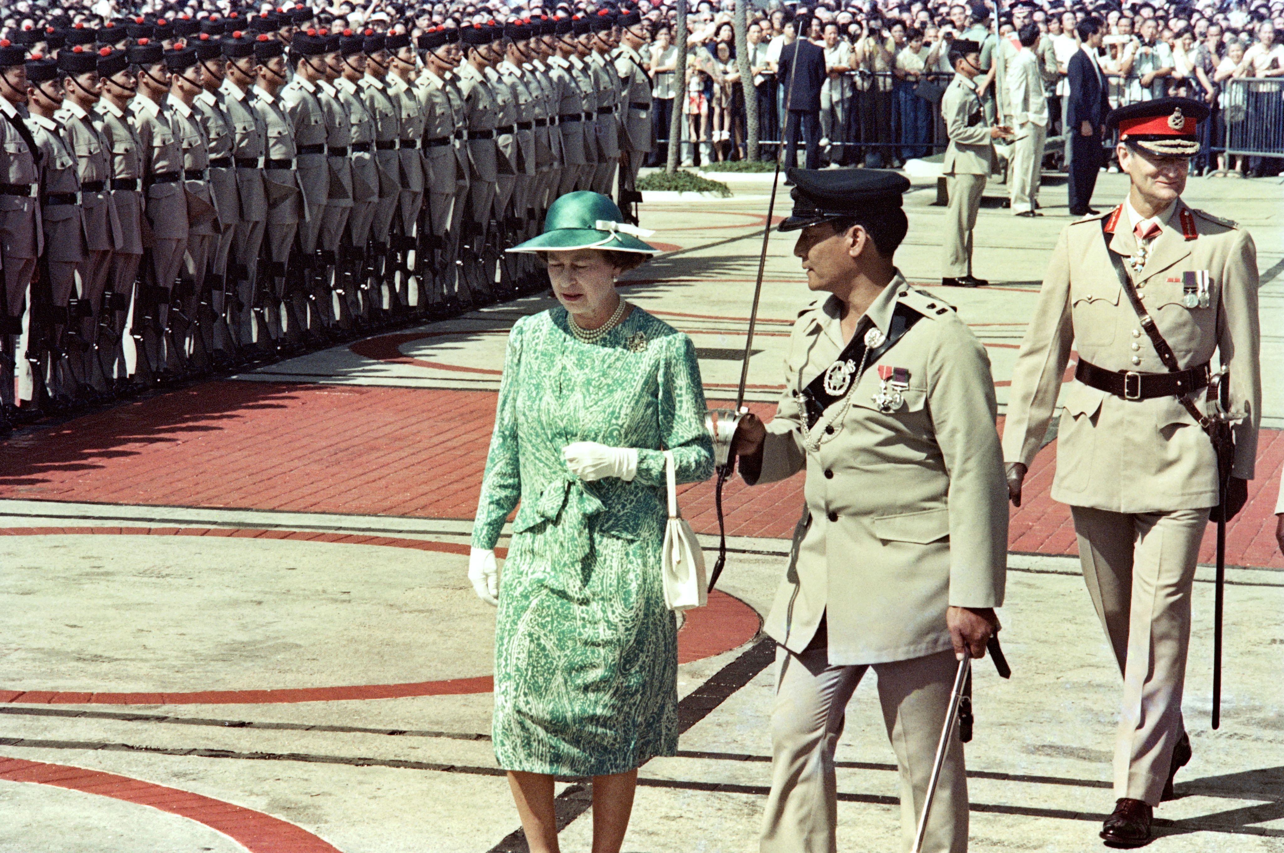 1986年10月21日，英国女王伊丽莎白二世在香港检阅仪仗队。(AFP / Yoshikazu MIKAMI)