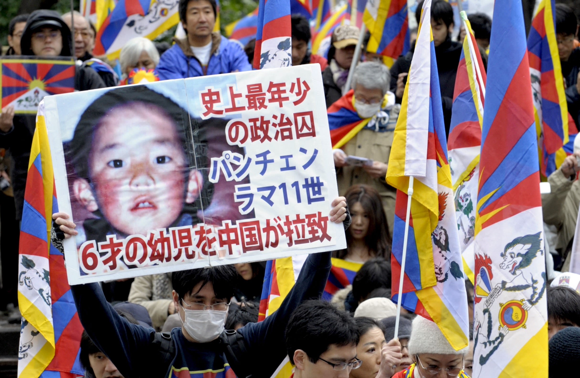 A protester holds a placard with portrait of Dalai Lama's choice for Panchen Lama, Gedhun Choekyi Nyima during a peace march in Tokyo on March 14, 2009 to mark the 50th anniversary of Tibetan uprising against Chinese rule. (AFP / Toshifumi Kitamura)