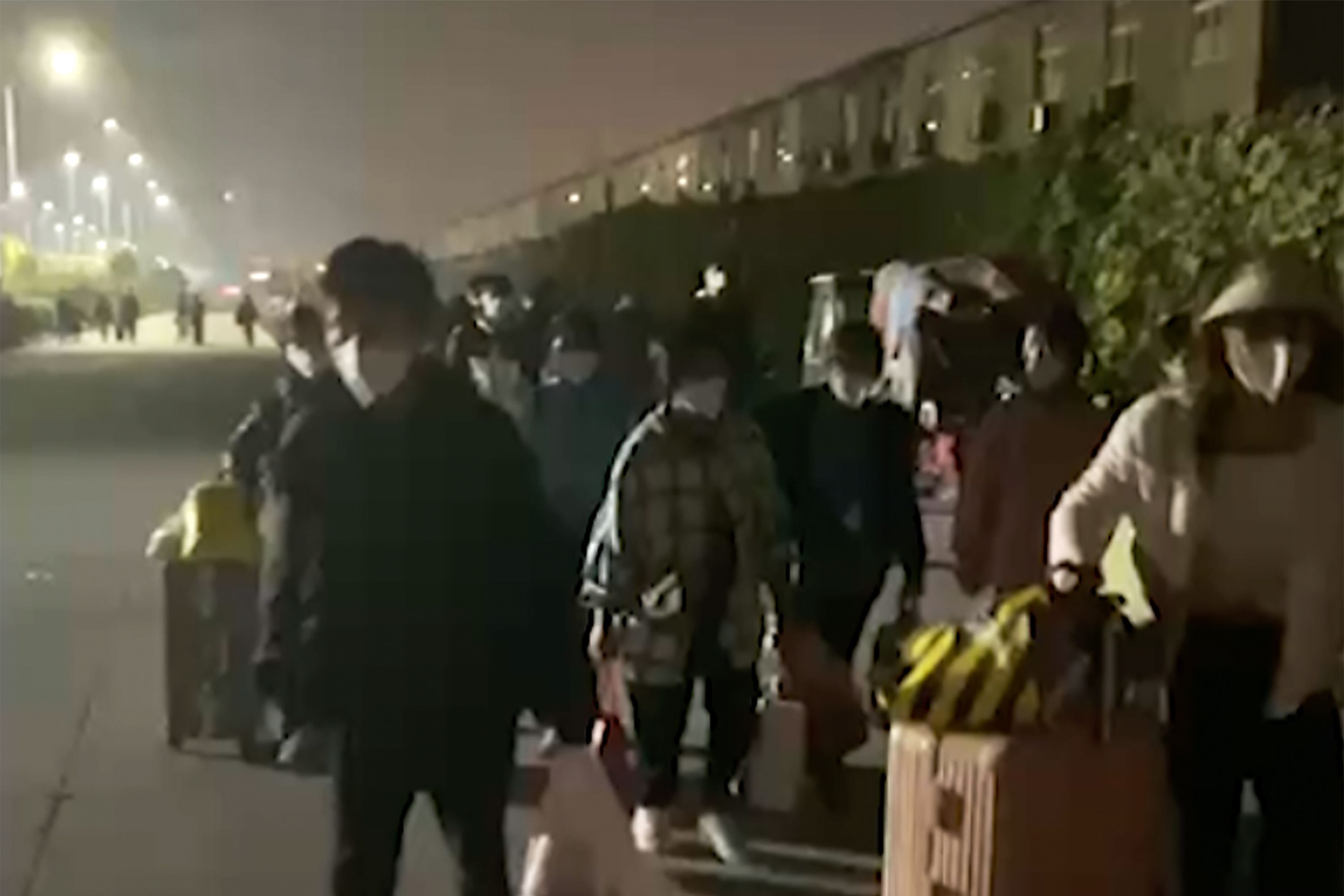带着行李逃离中国富士康郑州园区的工人。