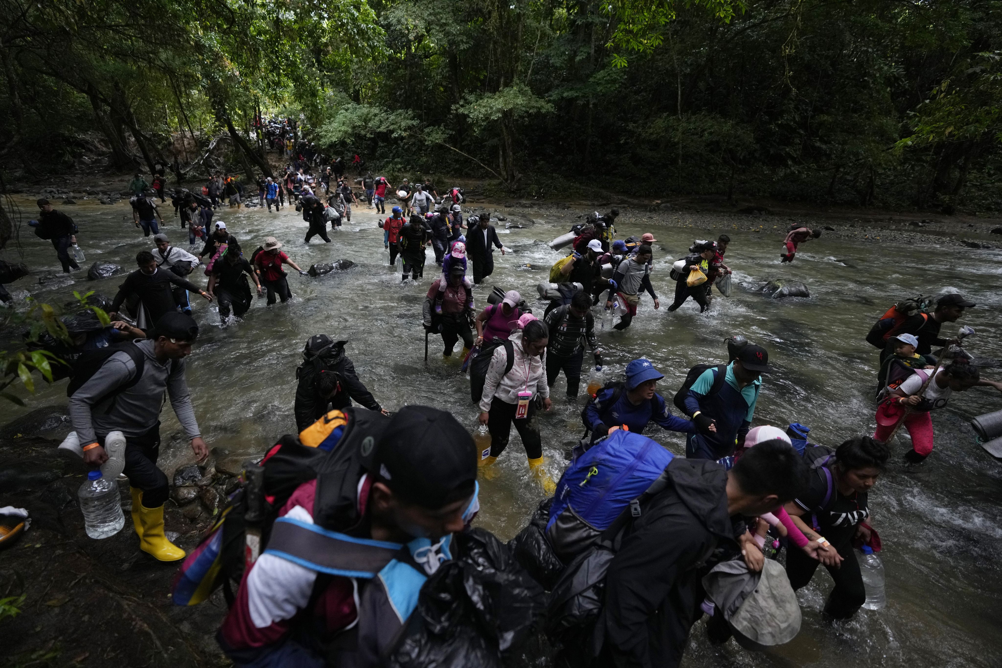 Migrants cross a river during their journey through the Darien Gap from Colombia into Panama, hoping to reach the U.S.