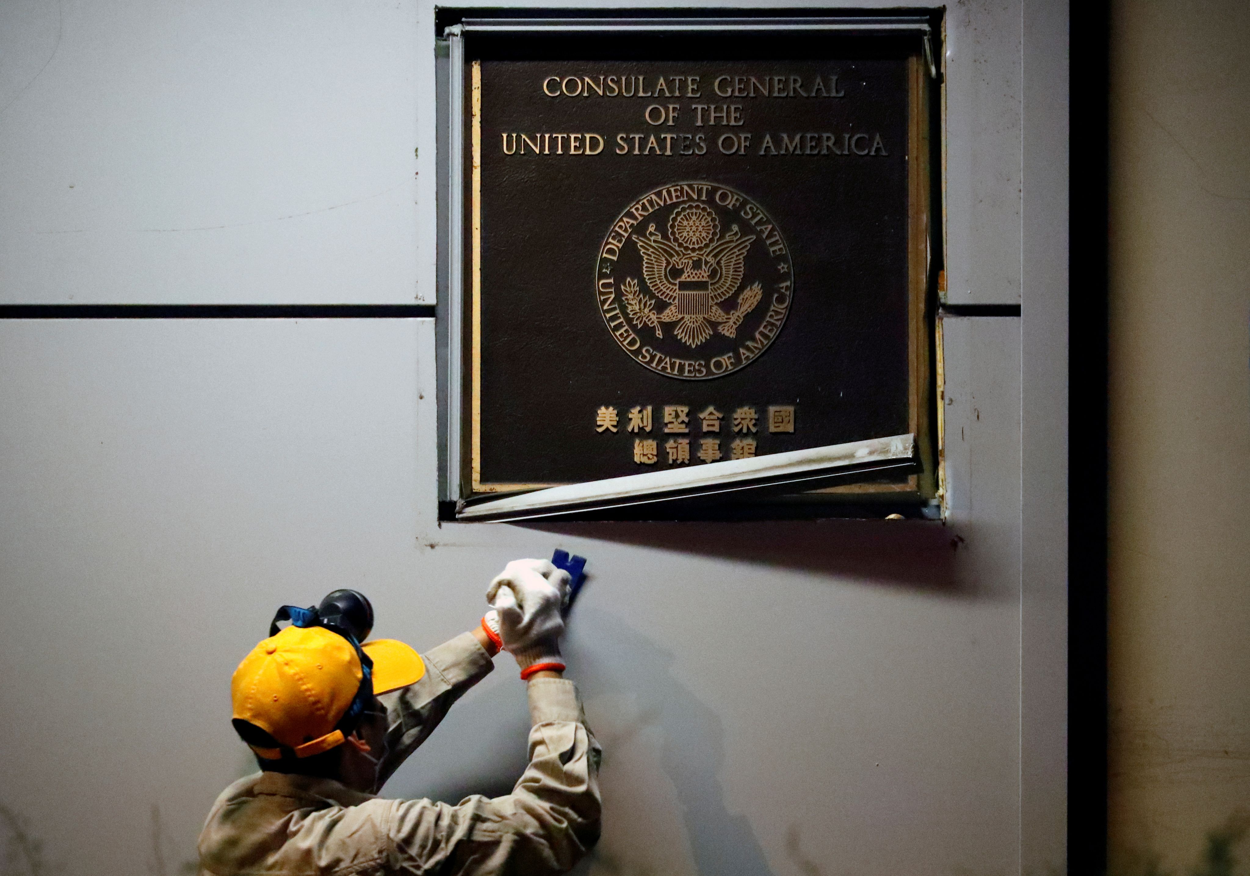 A man works to remove the U.S. Consulate plaque at the U.S. Consulate General in Chengdu