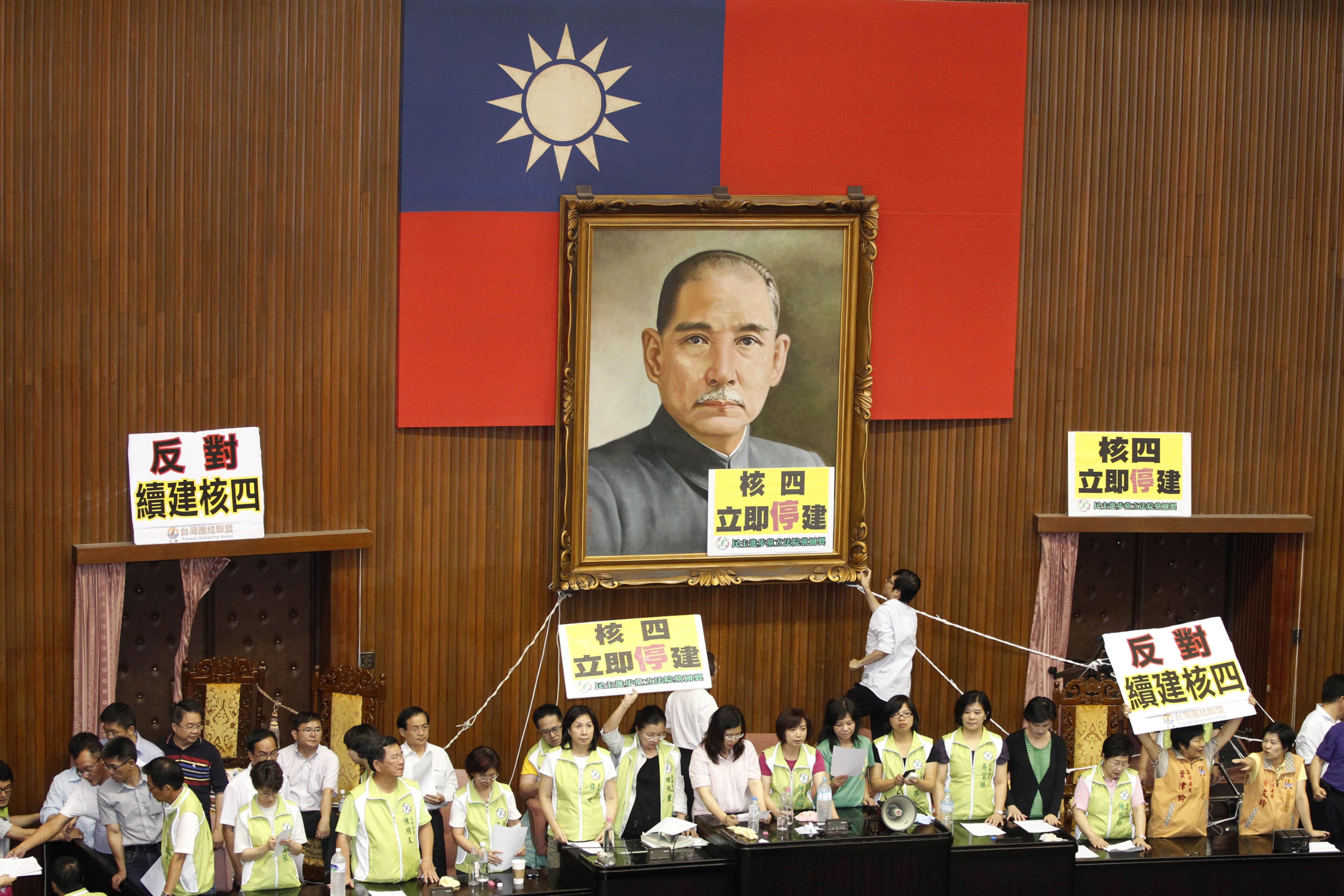 反对派在台北立法院的孙中山巨幅肖像上悬挂横幅，就是否继续建设第四座发电厂进行全民公投。