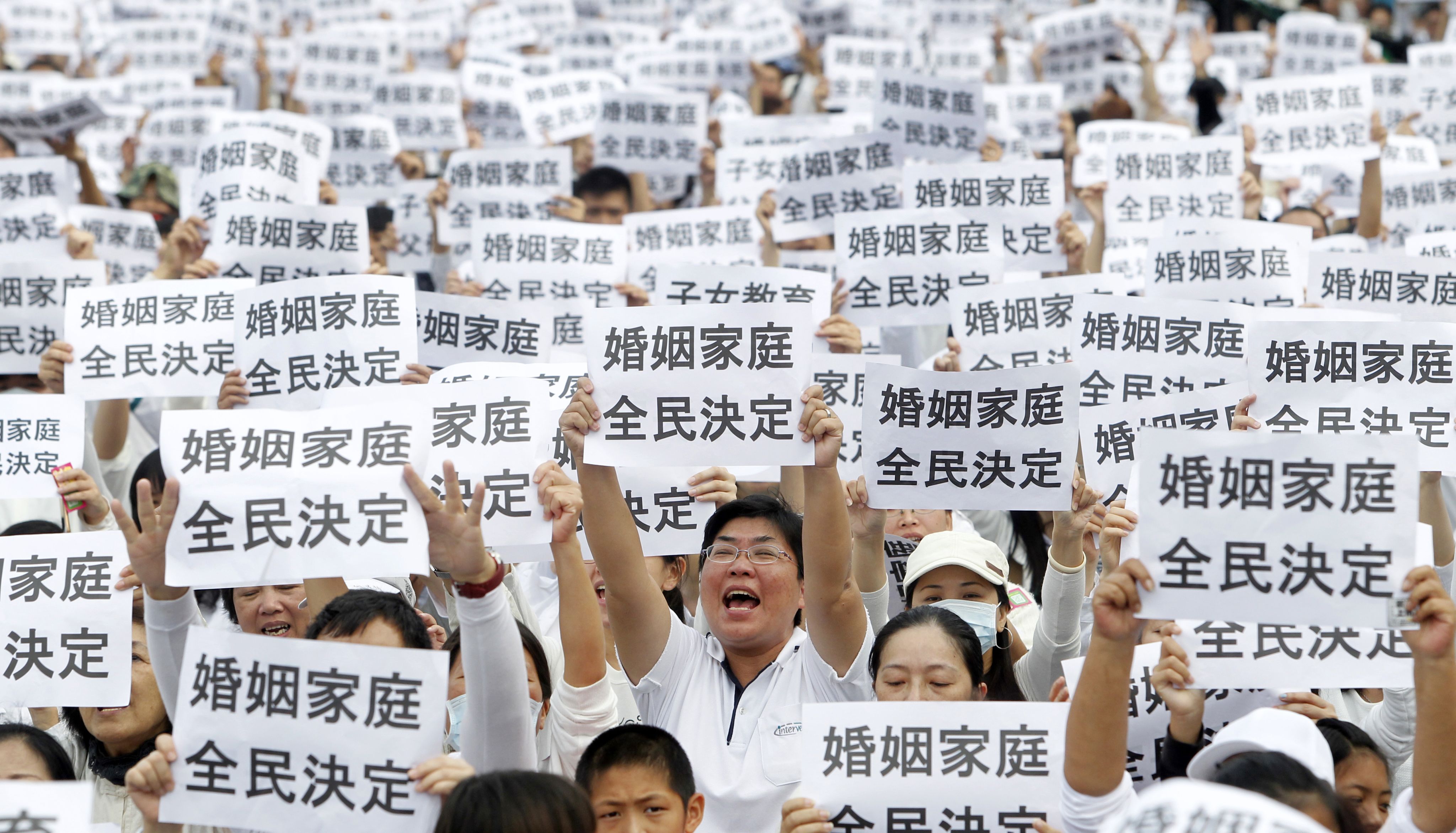 反对同性婚姻的抗议者在台湾台北举行的一次集会上高举标语，反对允许同性婚姻的提议。
