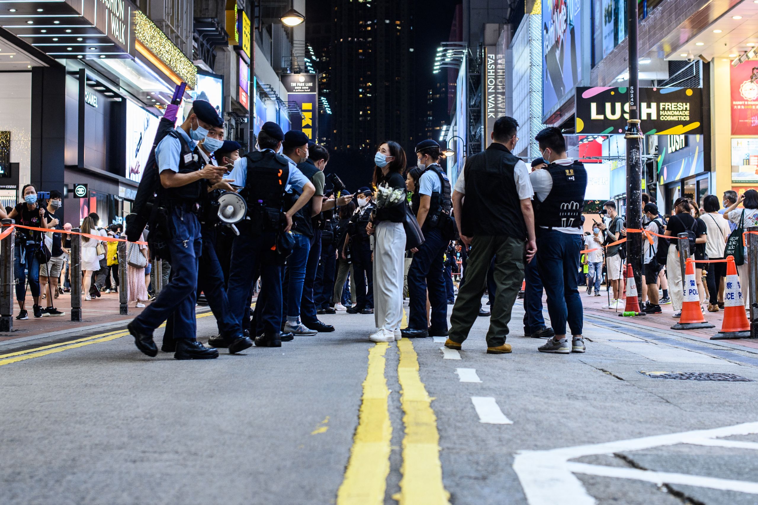 Hong Kong police searched the belongings of a woman holding flowers in a cordoned zoned at Causeway Bay.