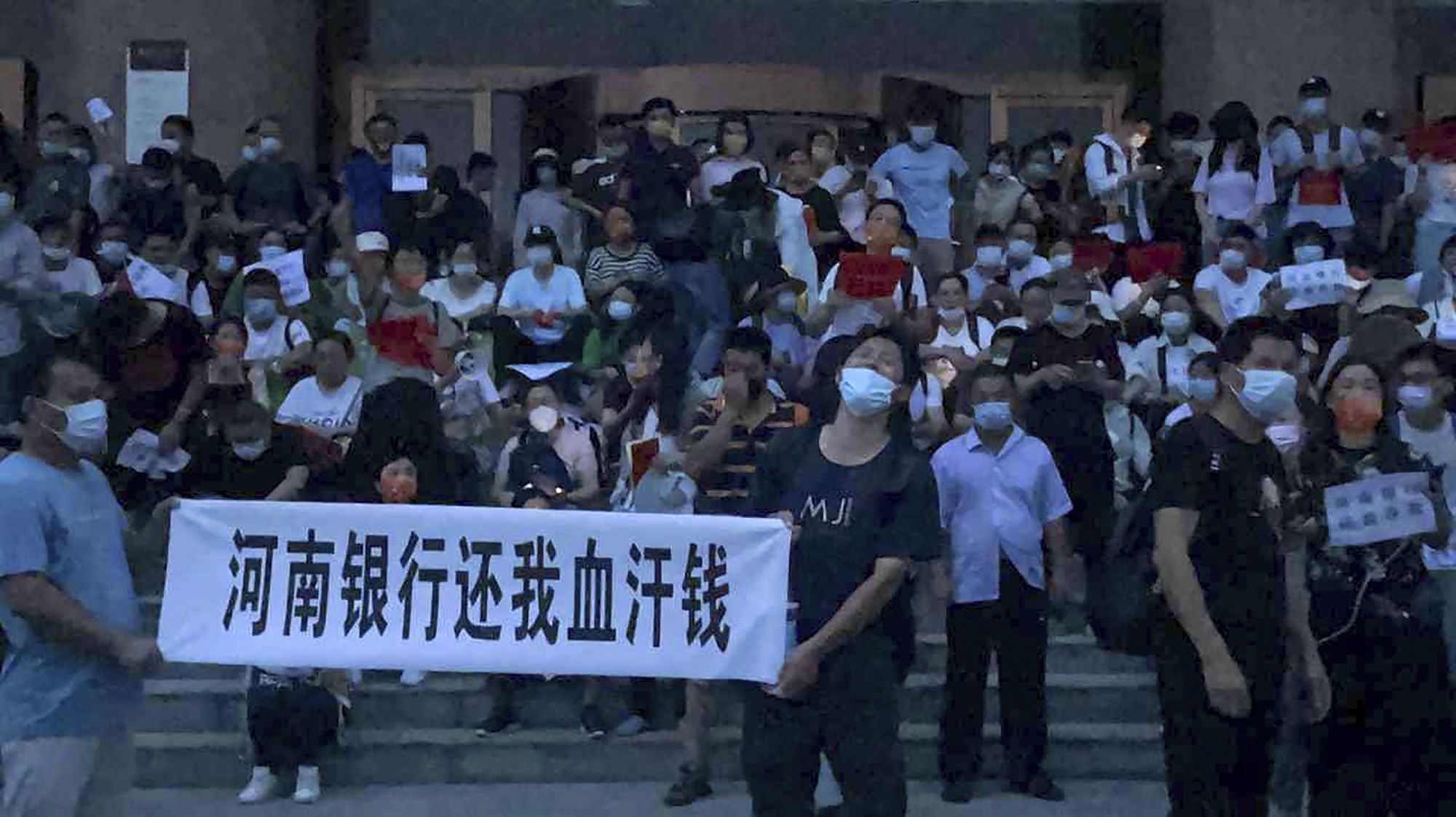 在中国人民银行郑州支行外，大批河南村镇银行储户聚集抗议 