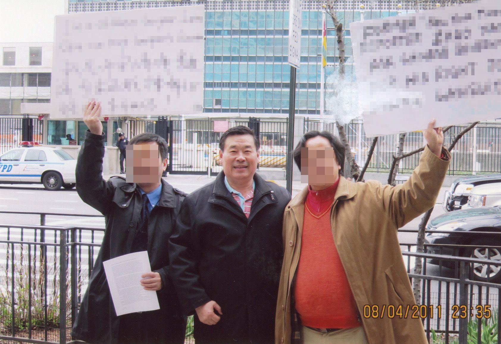 2011年8月，王书君与示威者在联合国前举牌抗议。（受访者提供）