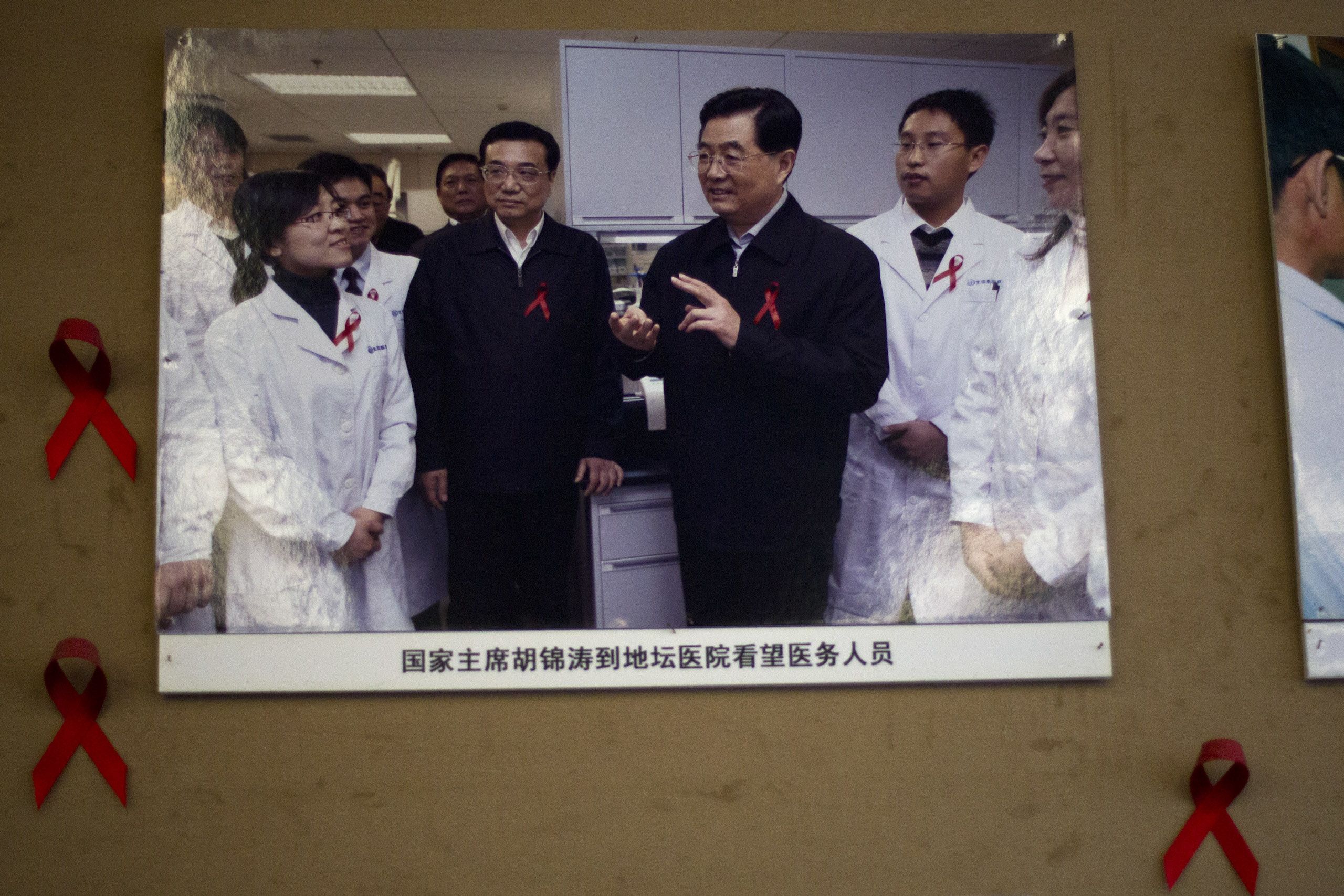 2012年11月30日，即世界艾滋病日的前一天，胡锦涛（右三）和副总理李克强（右四）在北京地坛医院的会议室参观。